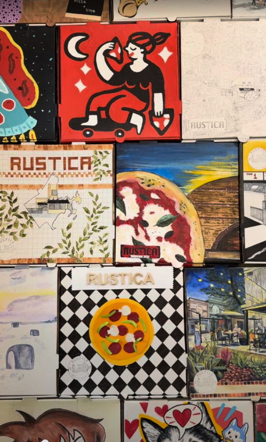 Colourful illustrated pizza boxes displayed on a wall inside Rustica, showcasing creative and unique designs